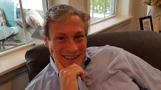 A man sitting on top of a couch smiling.